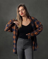 Woman in studio, in colorful shirt posing on gray background