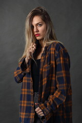 Woman in studio, in colorful shirt posing on gray background