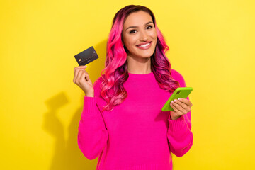 Fototapeta premium Photo of positive attractive lady hold telephone plastic debit card toothy smile isolated on yellow color background