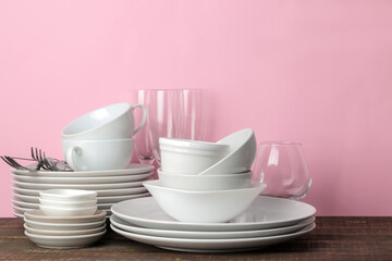many different dishes. Dinnerware. on a pink background. utensils for table setting. various plates, bowls and cups.