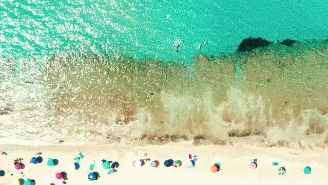 Top down aerial view of beach with colourful sun umbrellas and turquoise sea in the summer - Italy, Salento, Puglia, marina di taranto, Lizzano