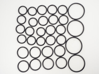 Hydraulic and pneumatic o-rings in black in different sizes on a white background. Rubber gaskets for plumbing. copy space.
