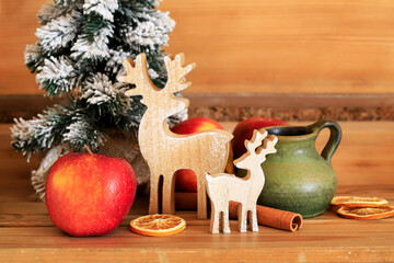 A ceramic jug for mulled vine on wooden table. Christmas decorations around.