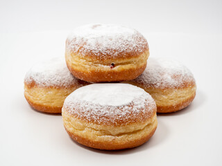 Obraz na płótnie Canvas Freshly baked and dusted with powdered sugar German donuts. Donut berliner or krapfen on white background.