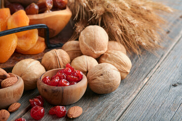 Tu Bishvat celebration concept. Mix of dry fruits and nuts almonds, hazelnuts, walnuts, apricots, prunes, cherries, raisins, dates, apples, figs over wooden table. Jewish holiday, new year of trees.