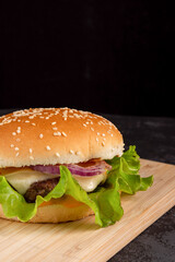 Burger with beef patty on a wooden plate