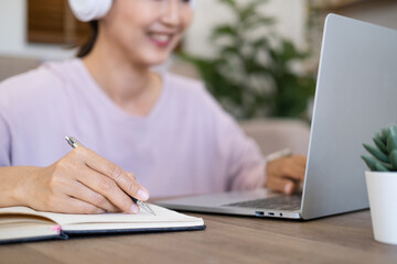 Smiling girl student wear wireless headphone study online with skype teacher, happy young woman...