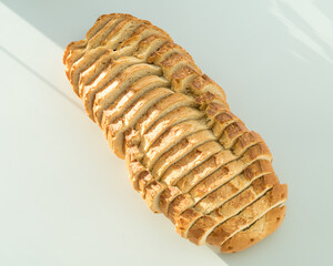 Pan rústico cortado a rebanadas sobre fondo blanco con luz natural.