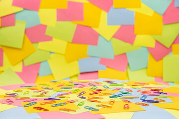 Multicolored paper clips on multicolored paper Sticky Notes