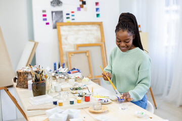 Young artist is working in her painting studio