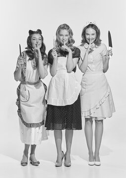 Retro style portrait of beautiful young women, housewives with cooking tools. Black and white image in vintage style