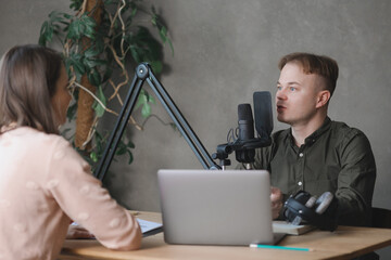 man and woman in studio record podcast, create audio content, advertising message. male radio host...