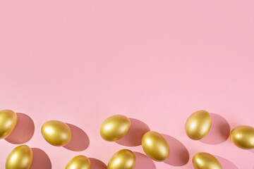 Easter template with golden egg border. Eggs painted gold on pink background. Easter concept with copy space for text. Flat lay style minimalistic design.