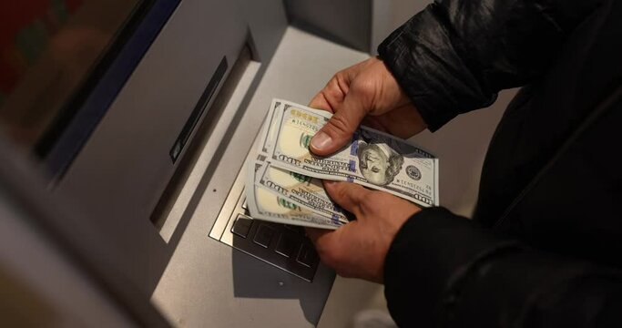 Male hands count money at the ATM, a close-up