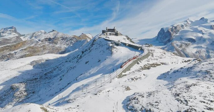 Aerial drone footage of Gornergrat bahn running from summit station on a sunny autumn day. Breathtaking view of Matterhorn railway in Zermatt ski resort in Swiss Alps. Switzerland travel journey trip.