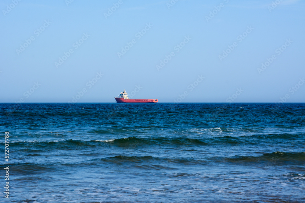 Wall mural sea view. sea and sky panorama. sea idyll. a lone freighter in the distance. small sea waves