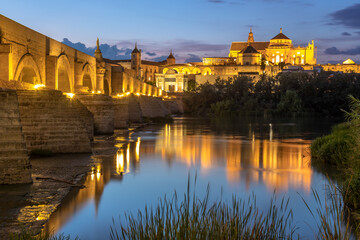 Night Exposure of the Roman bridge of and the Mosque–Cathedral of Córdoba in the background with the Guadalquivir river in the foreground