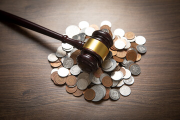 Stack of coins with judge gavel.