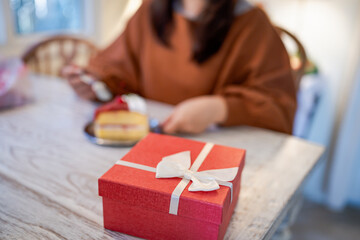 Happy Asian woman eating tasty Christmas fruit cake. Christmas Dinner Party with delicious piece of xmas cake New Year and Christmas concept