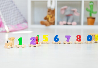 A child plays with a train made of numbers. Selective focus.