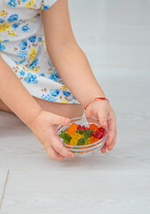 The child eats jelly candies. Selective focus.
