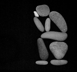 Man or woman in toilet made from many pebbles stones. Thinker sculpture parody. isolated on black background. human sitting on toilet seat thinking about something. isolated on black background.