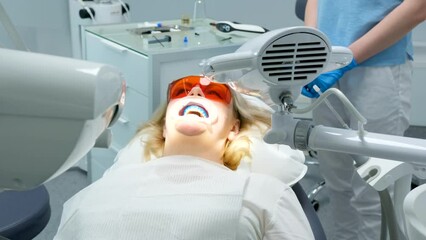 liquid cofferdam to isolate gums from action of bleaching agent optragat rotary spreader classical dental coloring for determining color of teeth woman in a dental chair is trying to communicate