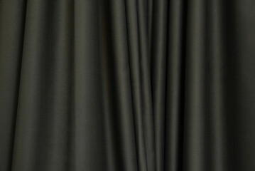 Dark brown curtains, folded in wavy, uneven, decorate the house for use as a background image.