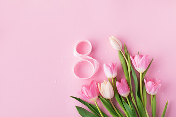 Greeting card for 8 March International Women Day with spring bouquet of tulip flowers on pastel pink top view.  Flat lay.