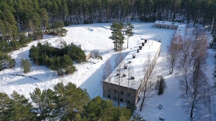 Abandoned Soviet military unit in a snowy forest. The complex of buildings of the old secret military unit of the USSR missile forces from a height under a layer of snow.