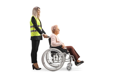 Special assitance worker standing behind a senior woman in a wheelchair