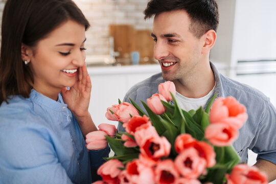 Picture showing man giving flowers to a woman at home. Romantic concept. Woman`s day