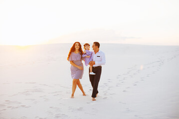 Family at sand dunes in most big sand desert in the world at sunset
