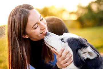 Siberian husky playing in grass outdoors with the owner girl together - Human and dog friendship and loyalty concept outside on a countryside field