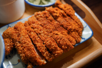 Taiwanese salted crispy pork on decorative plates with isolated wooden background