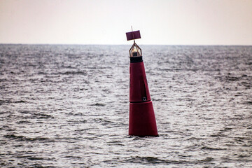 Red buoy floats in the sea close up