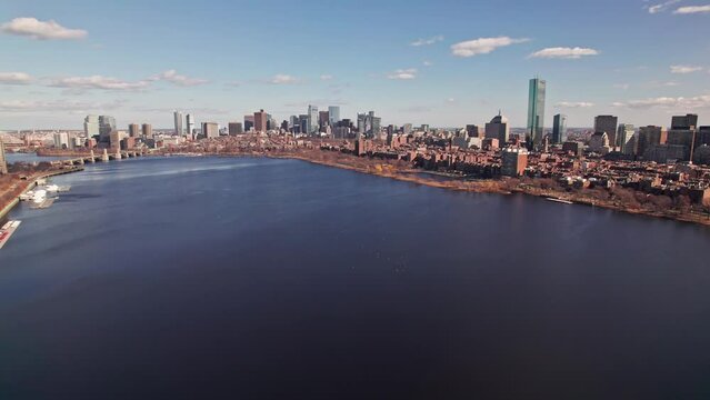 Drone and aerial establishing moving shot towards high-rise skyscrapers, tall apartments, and business developments in downtown Boston, Massachusetts on a sunny, winter day near the Charles River