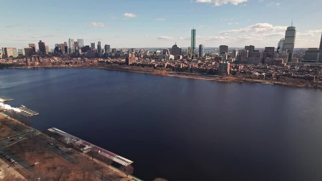 Drone and aerial establishing moving shot towards high-rise skyscrapers, tall apartments, and business developments in downtown Boston, Massachusetts on a sunny, winter day near the Charles River