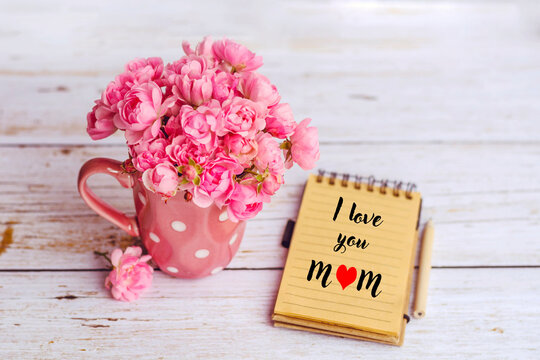 I love you mom greeting card with pink roses bouquet on a White Wooden Background 