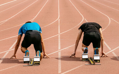 runners athletes in starting blocks for 100 meters race