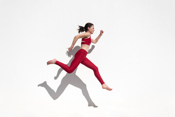 Fototapeta na wymiar Sporty woman running and jumping