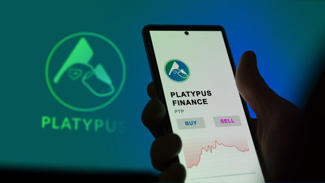 February 17 2023 London UK. An investor's analyzing the Platypus Finance coin on screen. A phone shows the crypto's prices to invest in PTP.