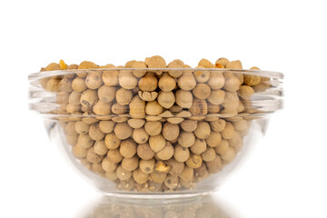 Fragrant vegetable coriander seeds in glass plate, macro, isolated on white background.
