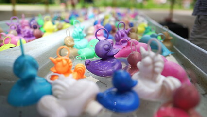 Rubber ducks at pool amusement park. fishing game at funfair festival party