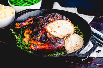 Sliced Apple Butter Roasted Chicken with a Carving Knife and Fork: Roast chicken in a cast iron pan with mashed potatoes and green beans