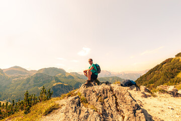 Obraz premium woman Hiking in the alps. Relaxing, resting on a Stone. Jenner Mountain - Berchtesgaden Alps, Germany, Bavaria, Schoenau am Königssee