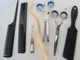 Set of hairdresser tools and hair. Shiny steel scissors and comb ready to use