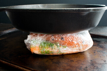 Making Homemade Lox with Salmon, Spices, and Salt: Salted salmon fillets wrapped in plastic and...