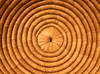Fototapeta premium background with concentric circles of wicker around a small hole in the middle lit by a warm light