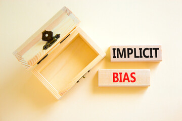Implicit bias symbol. Concept words Implicit bias on wooden block. Beautiful white table white background. Empthy opened wooden chest. Business psychology implicit bias concept. Copy space.